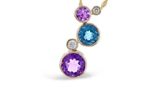 A journey necklace by Allison-Kaufman featuring blue and purple gems as well as diamonds
