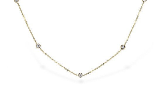 a delicate, yellow gold station necklace featuring round cut diamonds