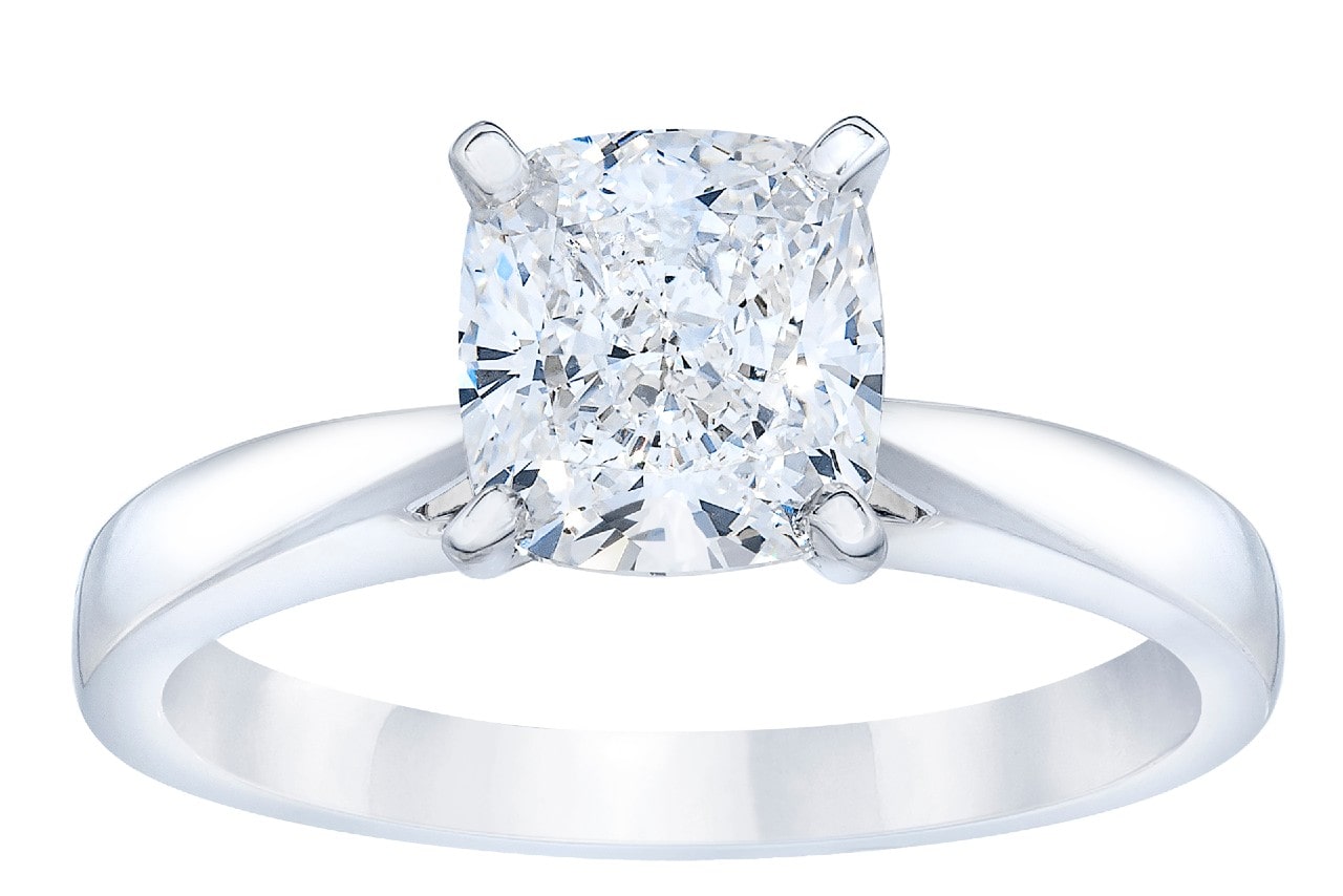 a white gold solitaire engagement ring with a cushion cut center stone