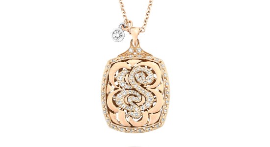 a yellow gold pendant necklace from TACORI featuring a diamond studded “S”