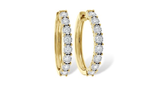 a pair of yellow gold huggies earrings set with round cut diamonds
