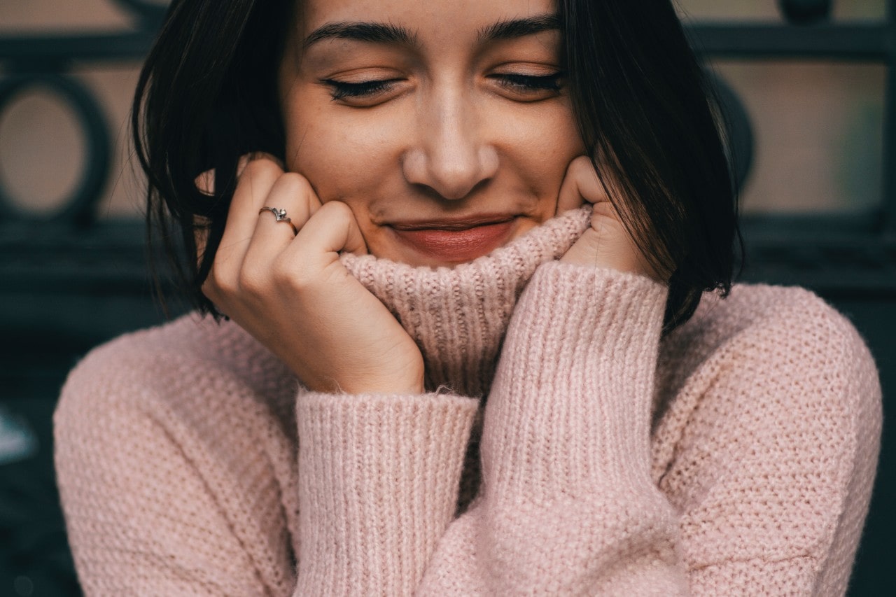 a woman wearing a nude turtleneck sweater and a minimalist fashion ring
