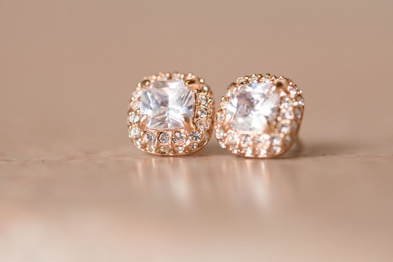 A close-up of stunning diamond stud earrings on a warm background.