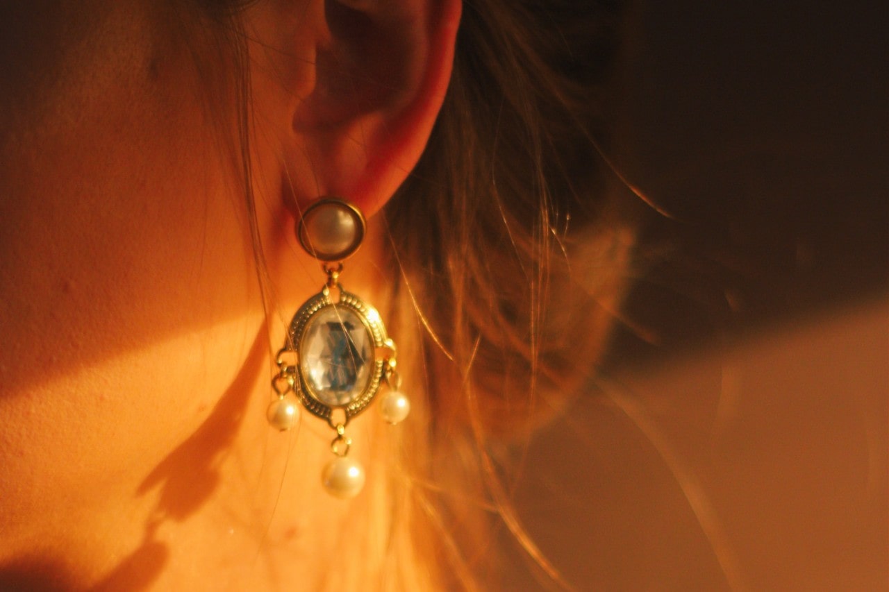 A close-up of a woman’s ear, adorned with an elegant earring.