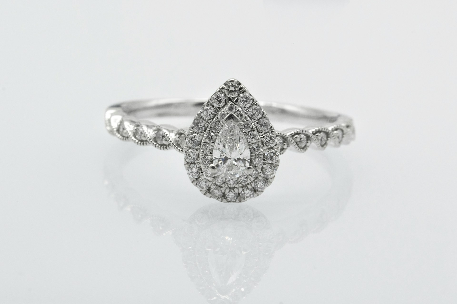 a pear shape diamond engagement ring with a double halo