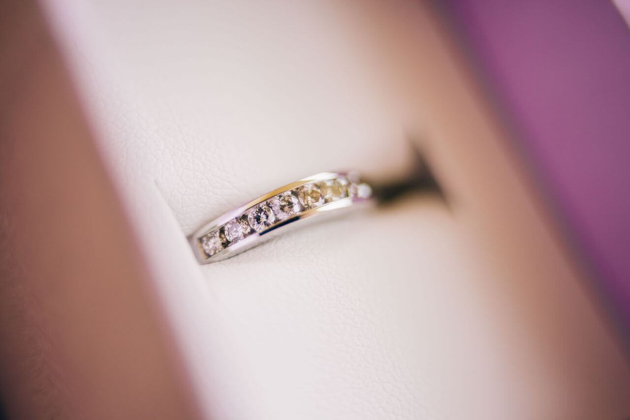 A channel-set diamond wedding band sits in a ring box.