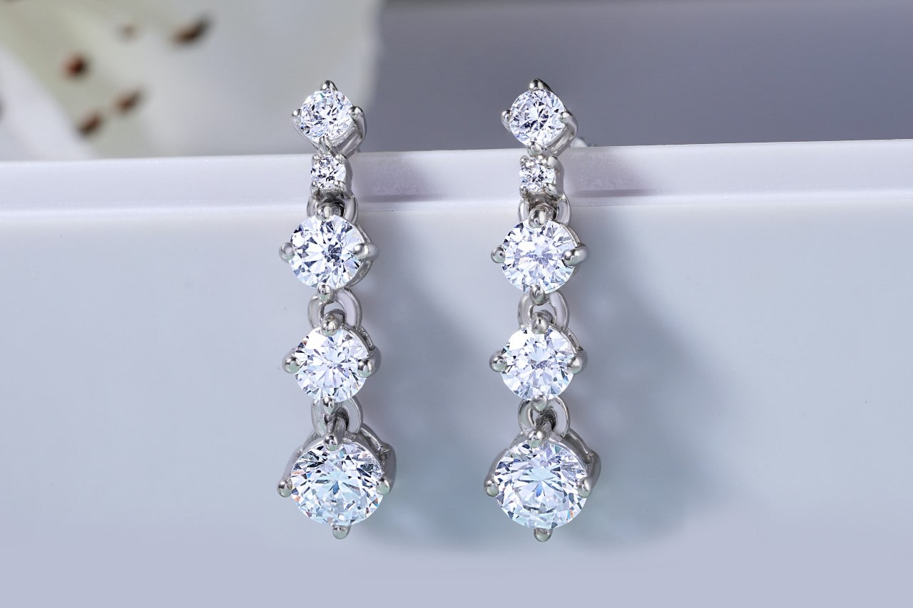 A close-up of elegant diamond earrings on a light background