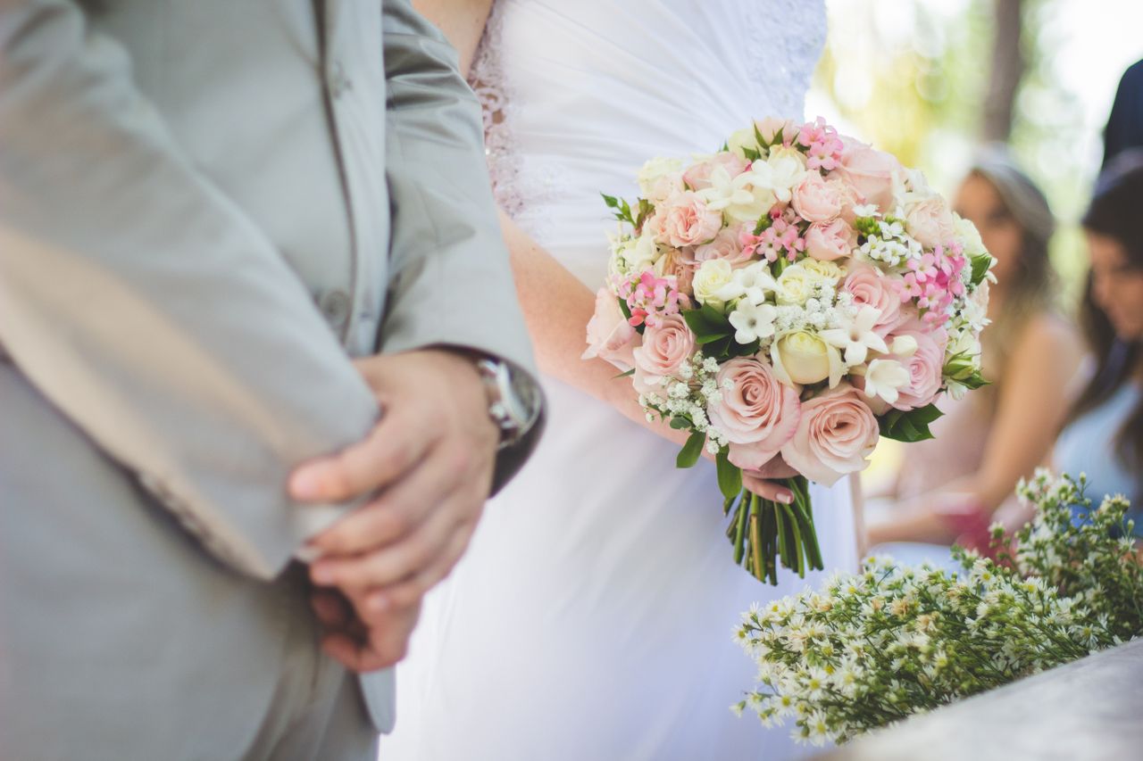 woman and man getting married holding flowers