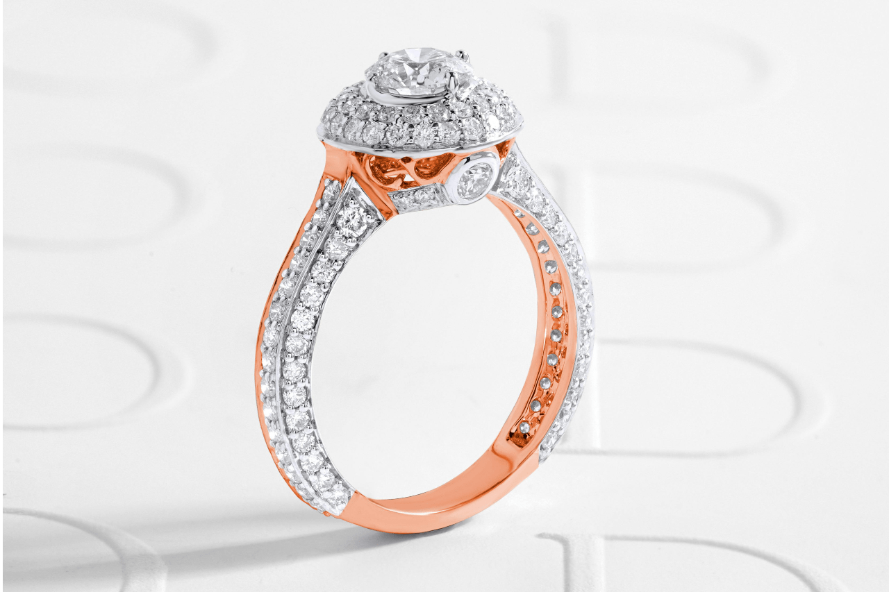 A mixed metal engagement ring with a rose gold band and double diamond halo.